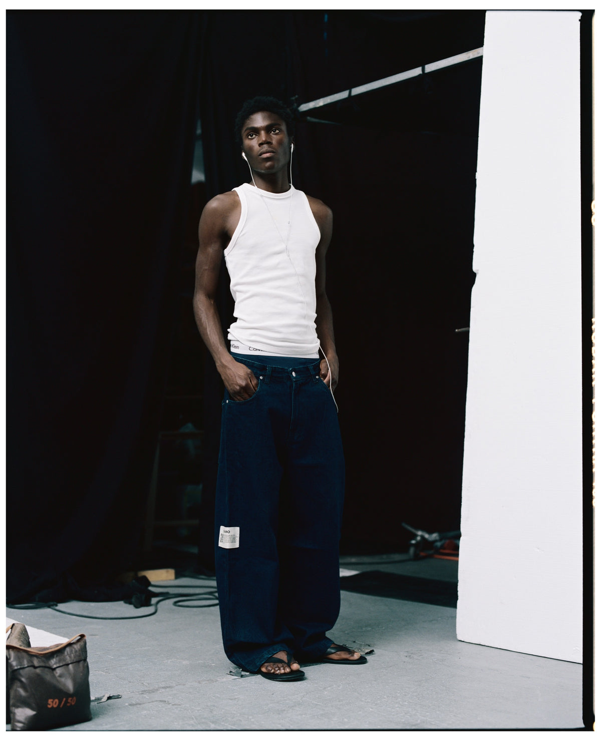 REAMO Denim lookbook – Sayeem raw denim with a white tank top in the studio
